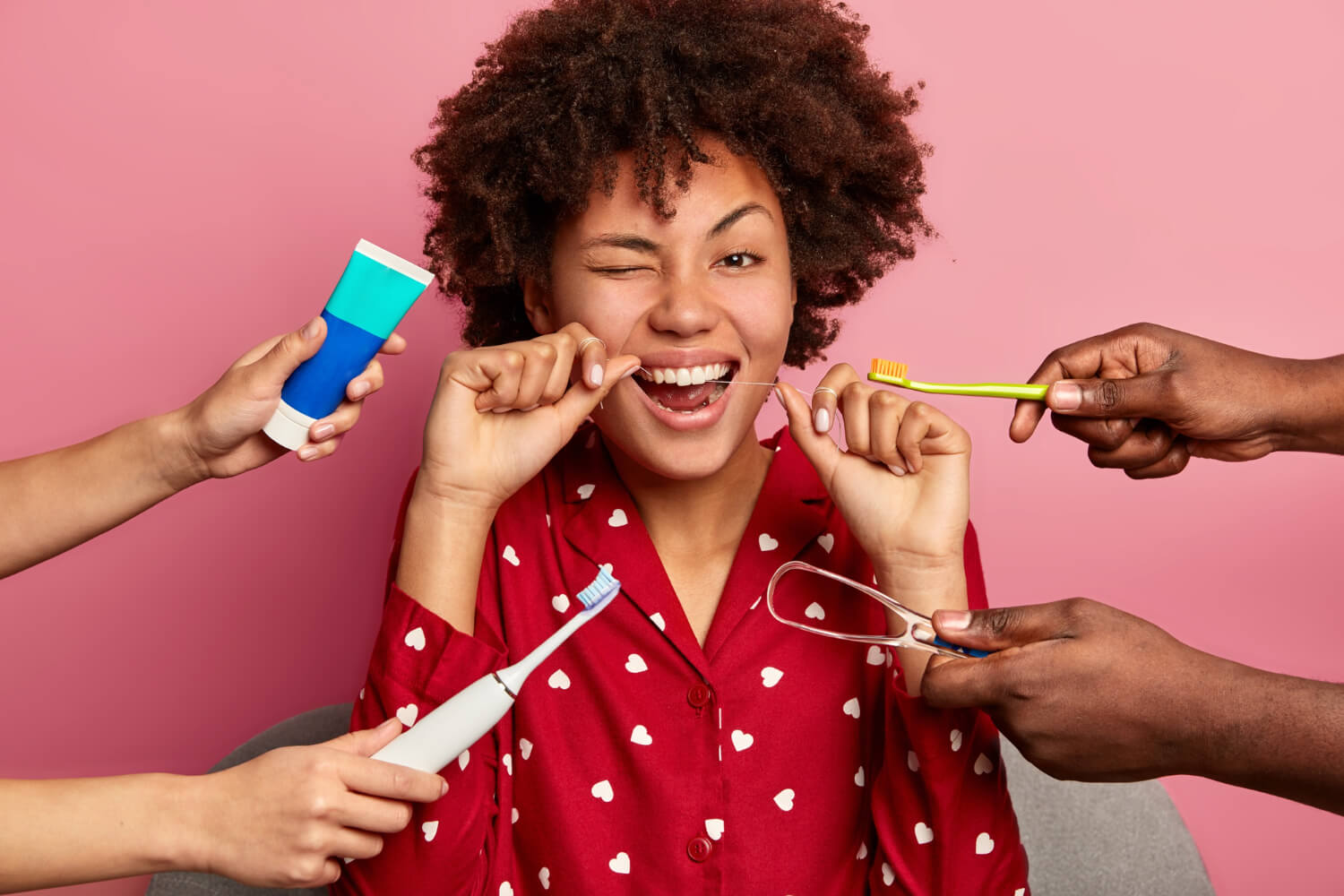 Mulher sorri usando fio dental para demonstrar como higienizar alinhadores Invisalign na Clínica Arte Dental, no Jd Anália Franco.